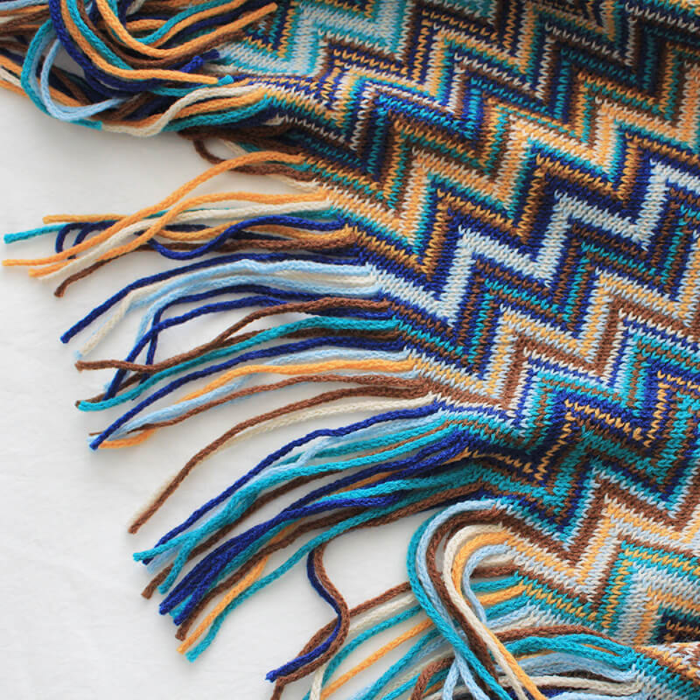 Plaid tricoté à pompons zigzag multicolore