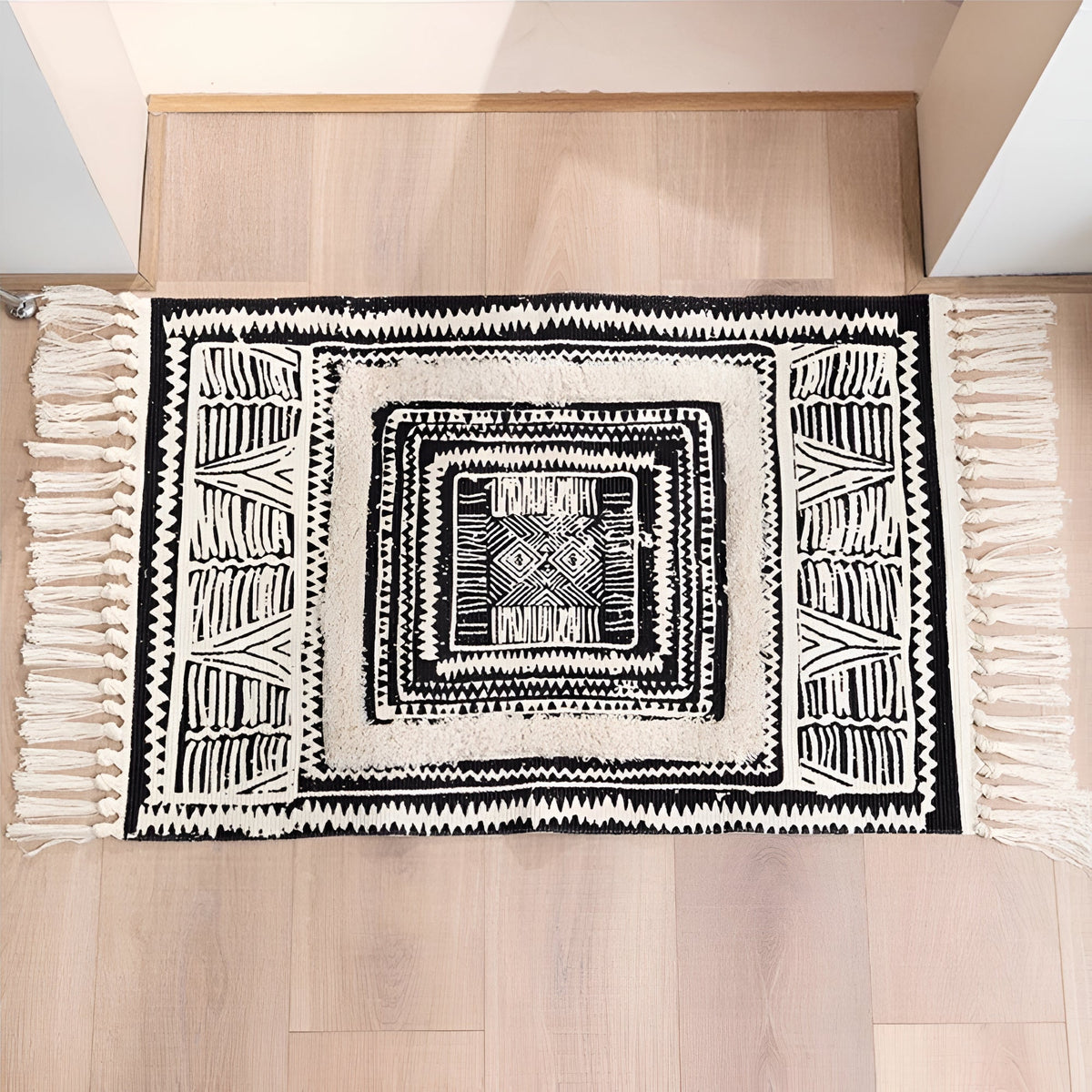 Tapis de sol géométrique noir et blanc à pompons